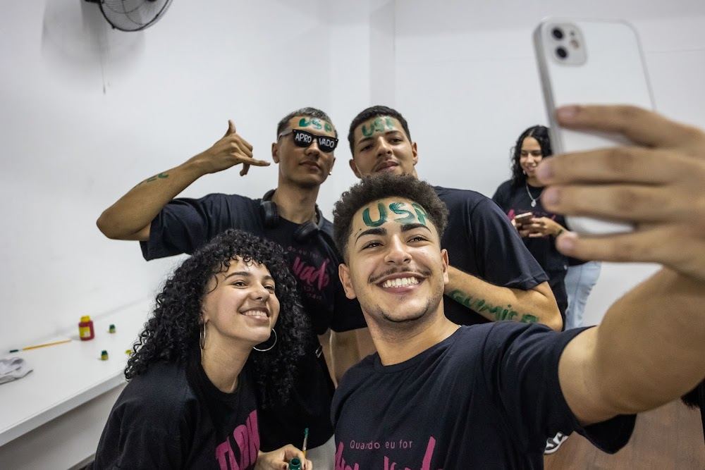 Alunos aprovados fazem selfie com nomes das universidades pintados no rosto